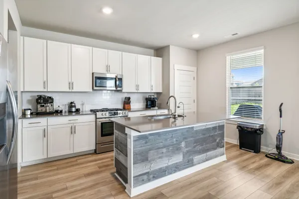 a kitchen with stainless steel appliances granite countertop a stove a sink and a refrigerator