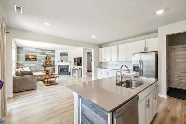 a kitchen with sink refrigerator and cabinets