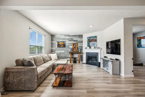 a living room with furniture a fireplace and a flat screen tv