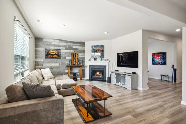 a living room with furniture a flat screen tv and a fireplace