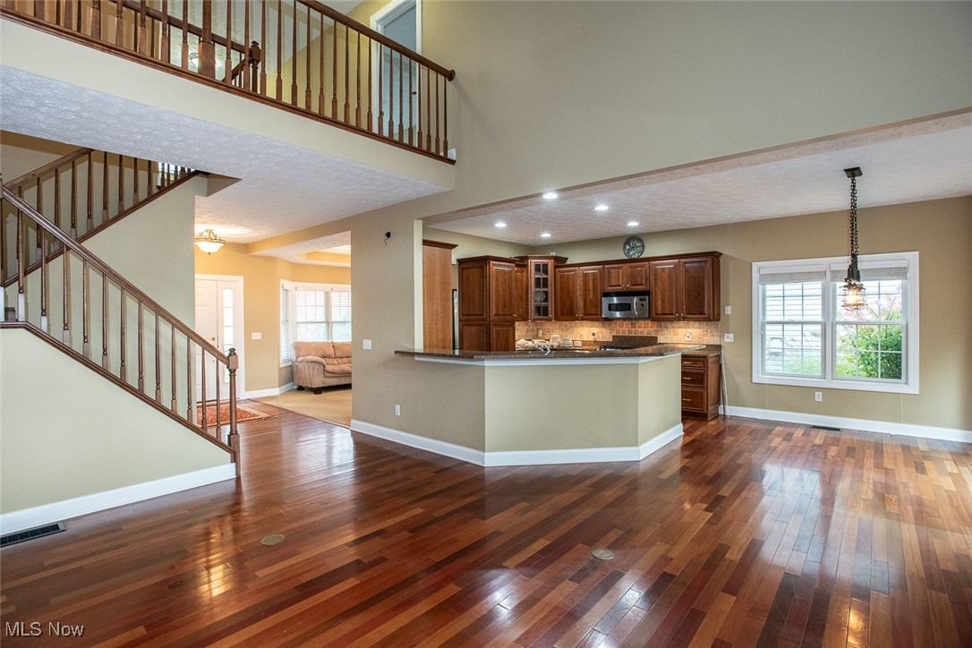 630 Rundle Street Lagrange, OH 44050 - Photo 49 of 49 Kitchen featuring open floor plan, glass insert cabinets, dark wood-style flooring, plenty of natural light, and a high ceiling