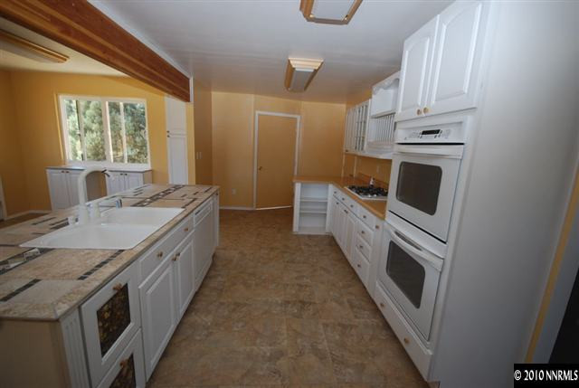 1885 Empire Road Reno, NV 89521 - Photo 3 of 13 a kitchen with granite countertop white cabinets and white appliances