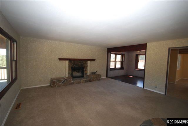 1885 Empire Road Reno, NV 89521 - Photo 4 of 13 an empty room with fireplace and windows