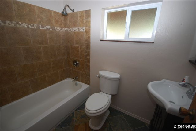 1885 Empire Road Reno, NV 89521 - Photo 6 of 13 a white toilet sitting next to a bathroom sink and tub