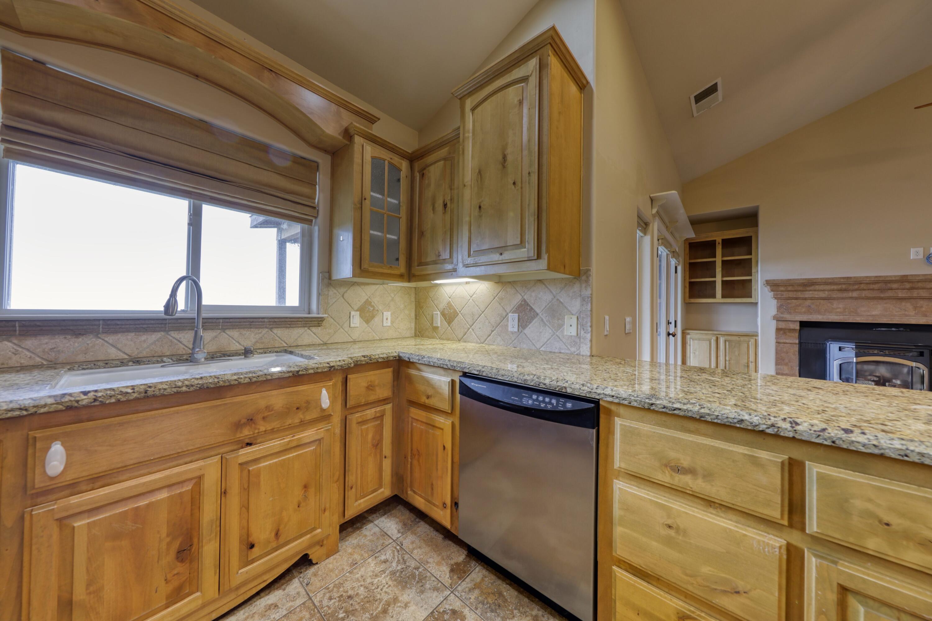 24281 Jacaranda Drive Tehachapi, CA 93561 - Photo 11 of 54 a kitchen with granite countertop cabinets stainless steel appliances a sink and a window