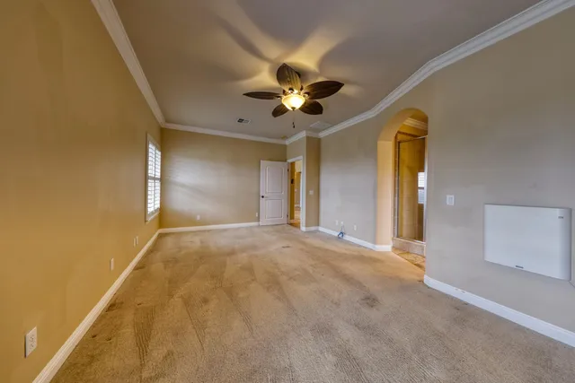 a view of an empty room and a ceiling fan