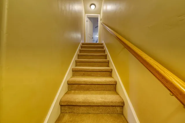 a view of an empty room and a ceiling fan and window