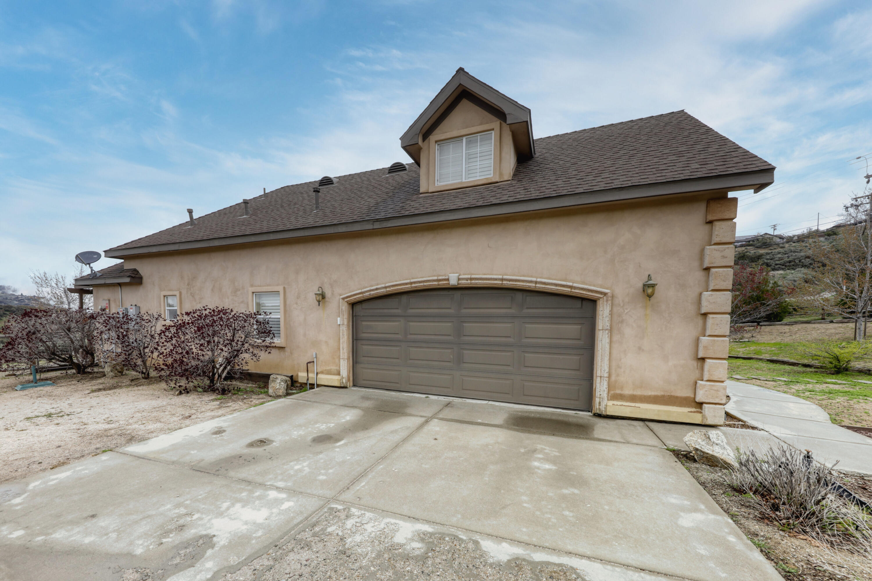 24281 Jacaranda Drive Tehachapi, CA 93561 - Photo 52 of 54 a front view of a house with a yard and garage