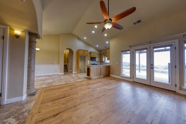 a view of an empty room with window and wooden floor