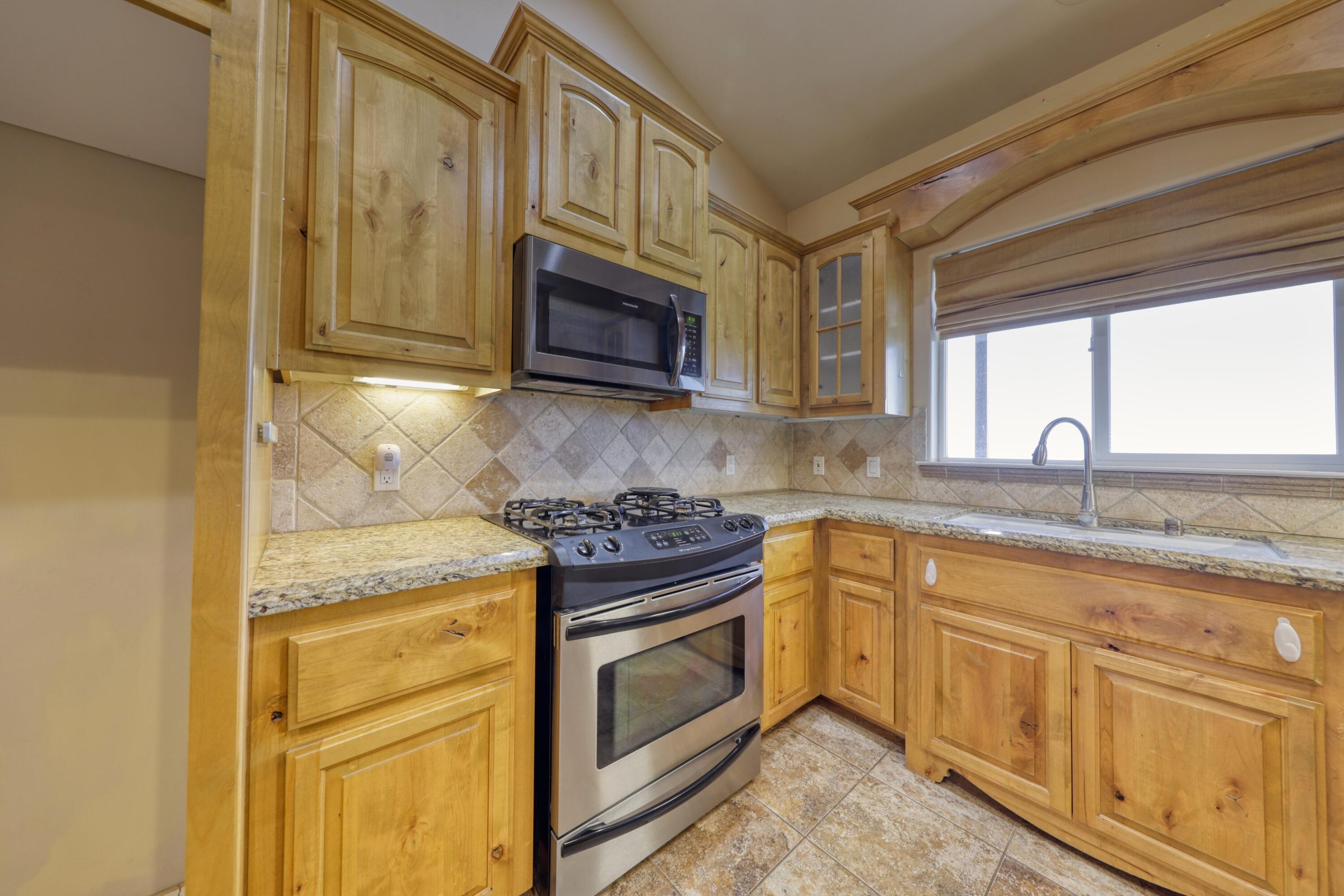 24281 Jacaranda Drive Tehachapi, CA 93561 - Photo 10 of 54 a kitchen with granite countertop a stove sink and microwave