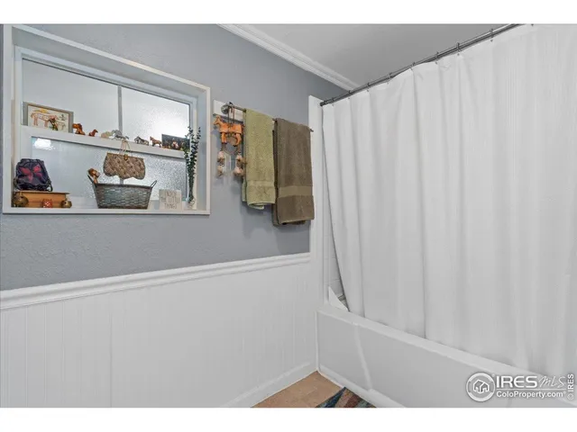 a bed sitting in a spacious bedroom next to a window