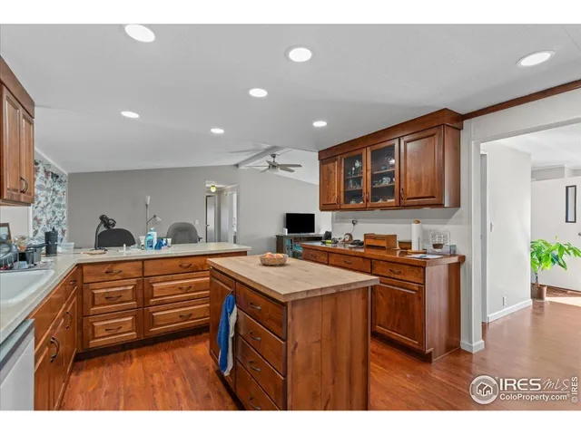 a kitchen with stainless steel appliances granite countertop a sink a stove a refrigerator cabinets and a dining table