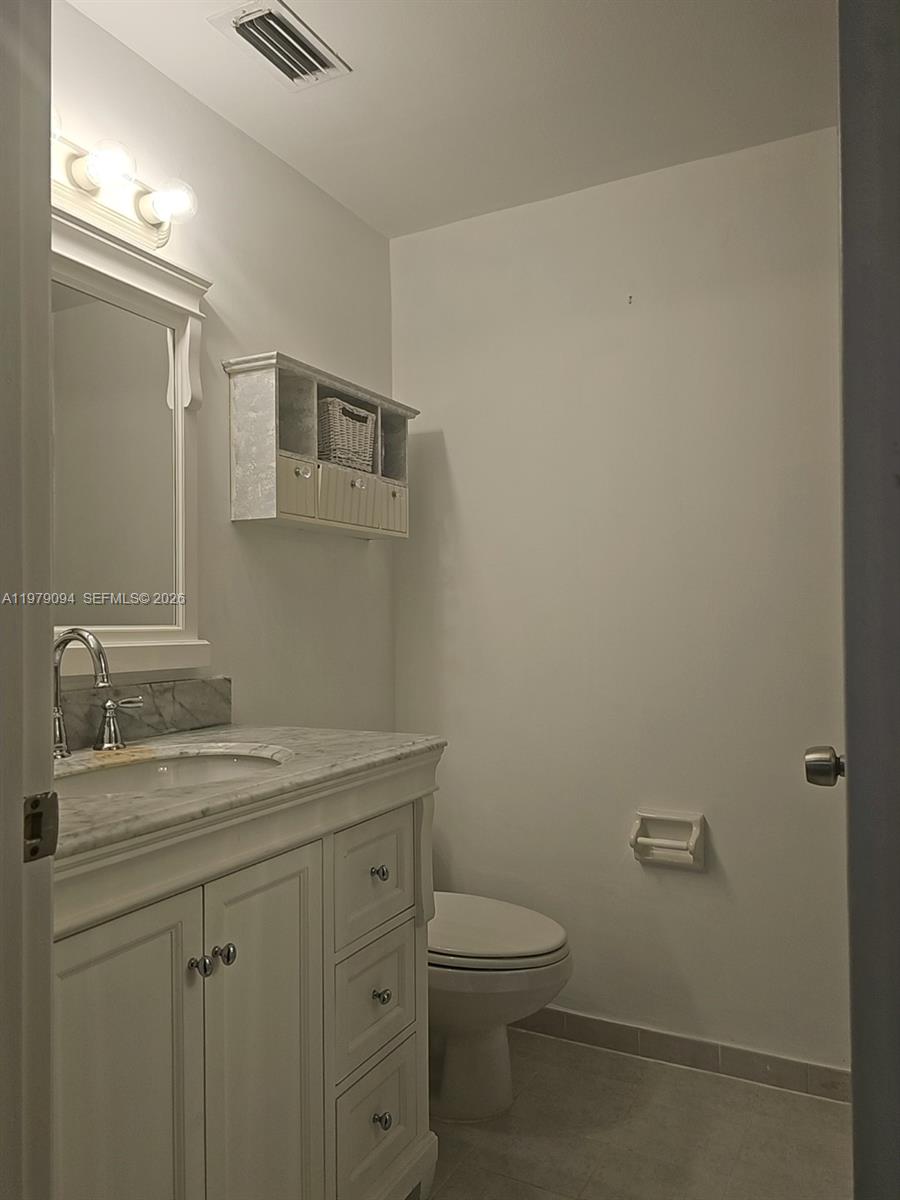 7870 Southwest 102nd Lane Miami, FL 33156 - Photo 33 of 41 a bathroom with a granite countertop sink a toilet and mirror