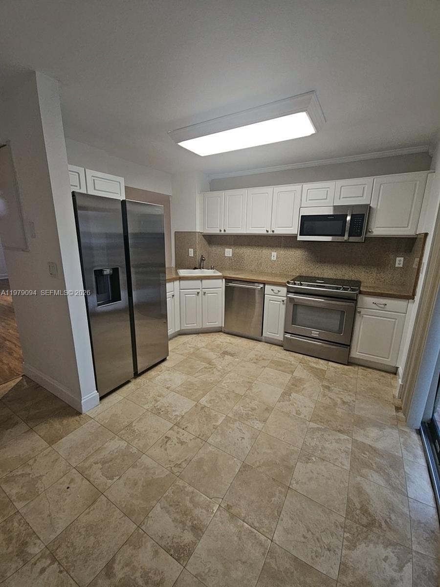 7870 Southwest 102nd Lane Miami, FL 33156 - Photo 9 of 41 a room with a refrigerator and a sink