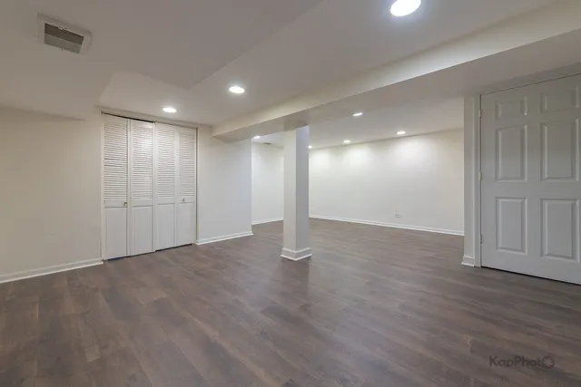 a view of empty room with wooden floor