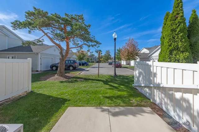 a view of a house with a small yard and a large tree