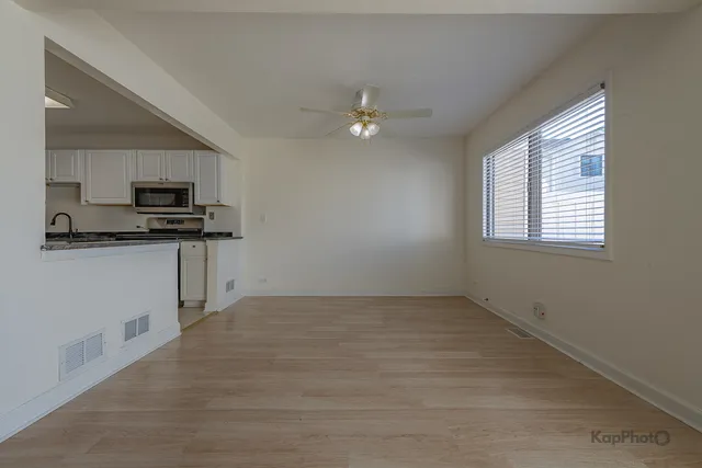 an empty room with a window and a kitchen