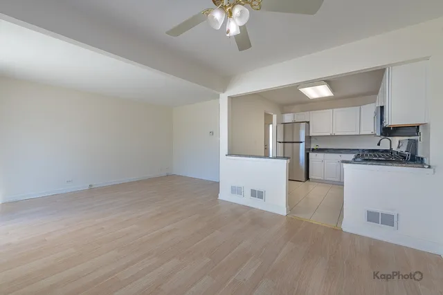 a view of kitchen with granite countertop cabinets and refrigerator