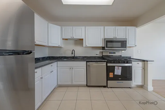 a kitchen with cabinets stainless steel appliances and a sink