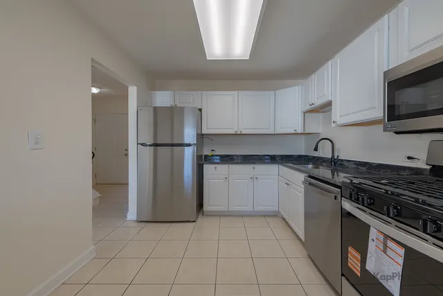 a kitchen with a refrigerator a stove top oven a sink and dishwasher