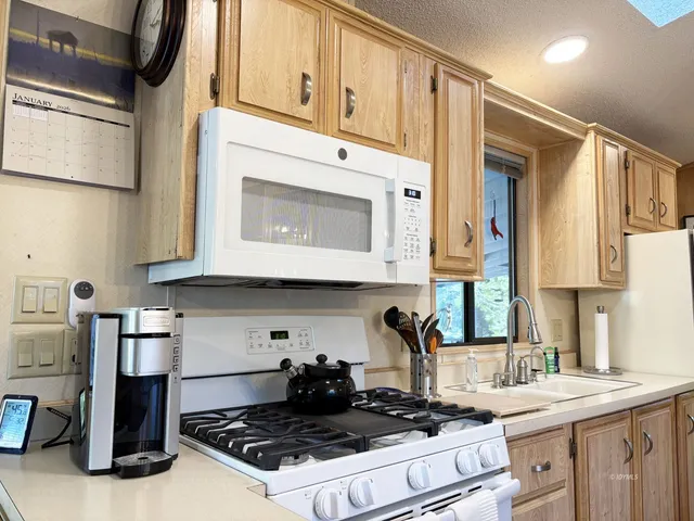 a kitchen with stainless steel appliances granite countertop a stove a sink and a microwave
