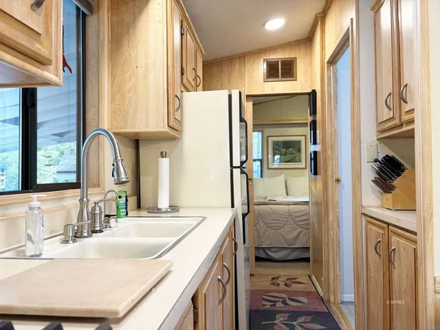 a en suite bathroom with a granite countertop sink and a large mirror