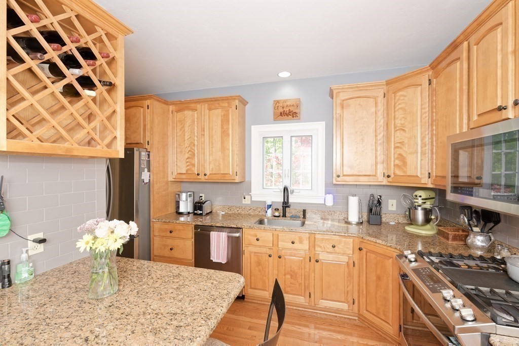 16 Bridle Path Shrewsbury, MA 01545 - Photo 23 of 42 a kitchen with a stove a sink a microwave cabinets and dining table