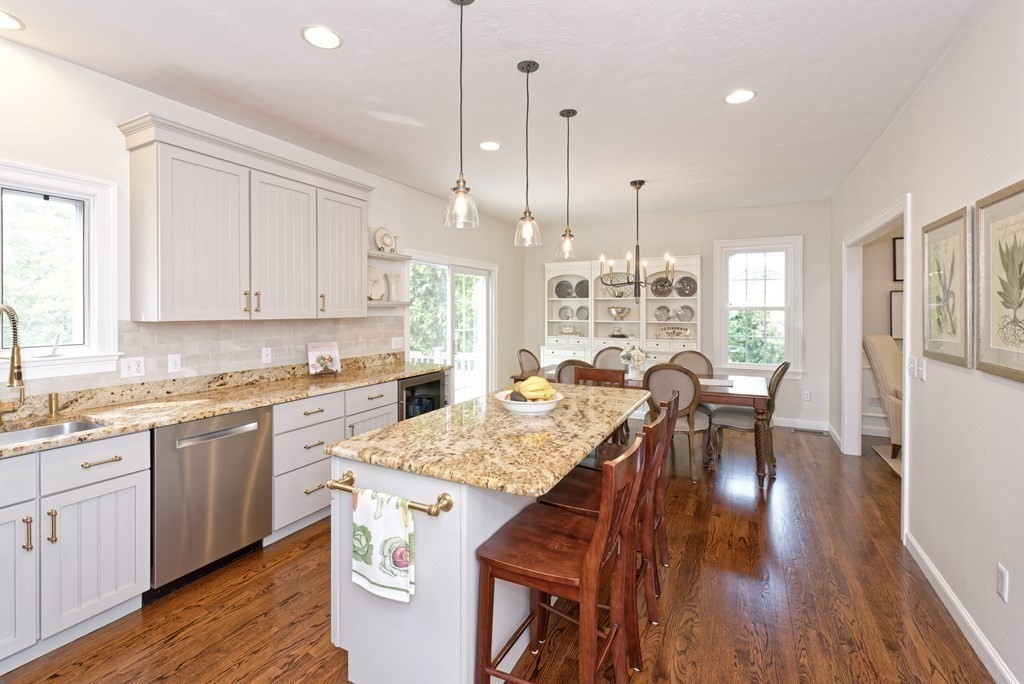 16 Bridle Path Shrewsbury, MA 01545 - Photo 5 of 42 a open kitchen with stainless steel appliances granite countertop a stove top oven a sink a dining table and chairs with wooden floor