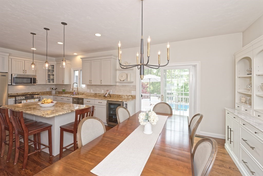 16 Bridle Path Shrewsbury, MA 01545 - Photo 6 of 42 a kitchen with stainless steel appliances granite countertop a stove a kitchen island a dining table and chairs with wooden floor