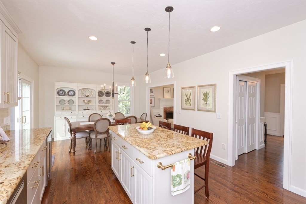 16 Bridle Path Shrewsbury, MA 01545 - Photo 7 of 42 a open kitchen with stainless steel appliances granite countertop a stove top oven a refrigerator a dining table and chairs with wooden floor