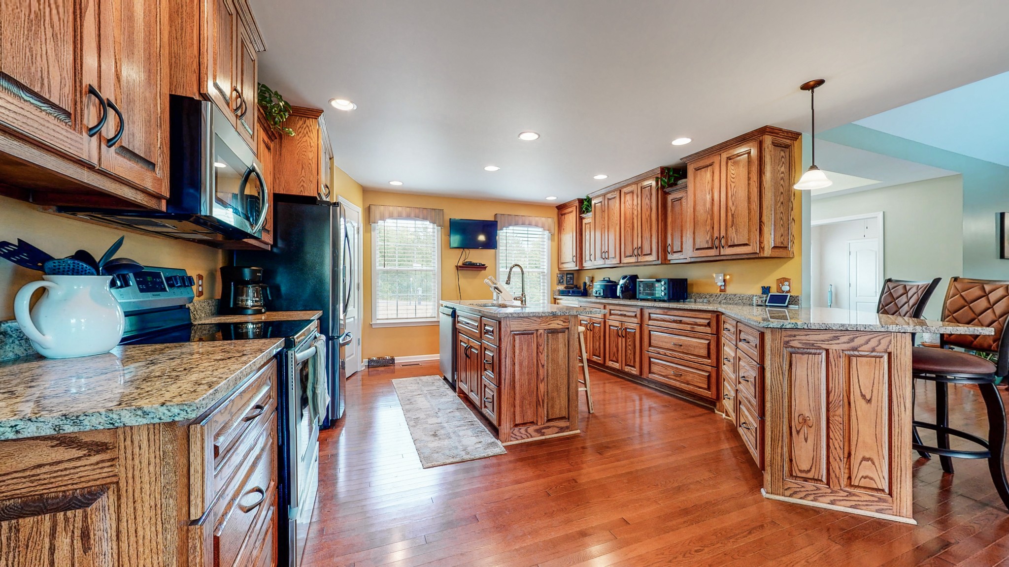 1439 Cliff Amos Road Spring Hill, TN 37174 - Photo 5 of 64 a kitchen with stainless steel appliances granite countertop wooden cabinets a center island and a stove
