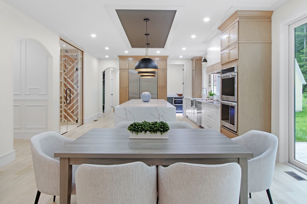 293 Cross Street Norwell, MA 02061 - Photo 10 of 38 a kitchen with stainless steel appliances a dining table chairs and refrigerator