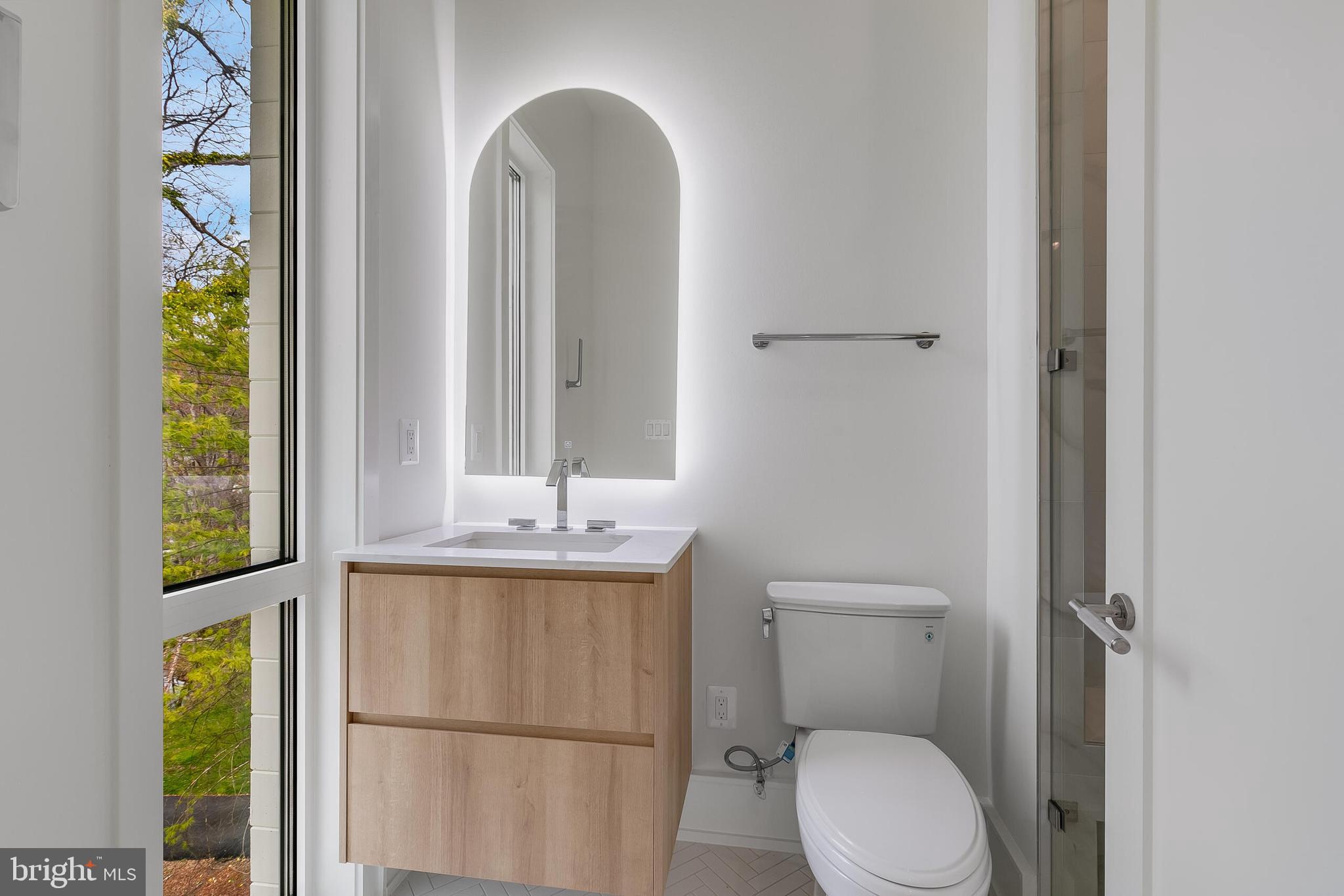8757 Brook Road McLean, VA 22102 - Photo 32 of 45 a bathroom with a toilet a sink and a window