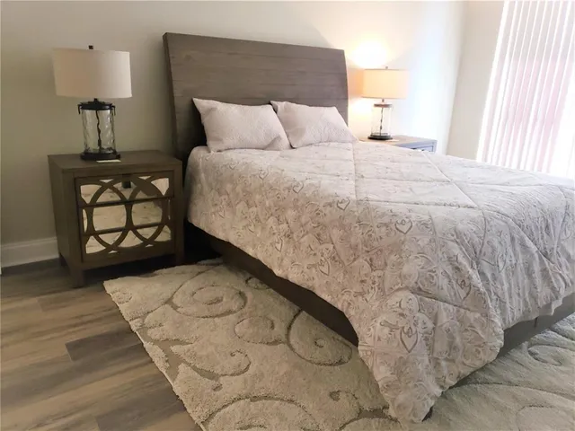 a bed sitting in a bedroom next to a window with lamp