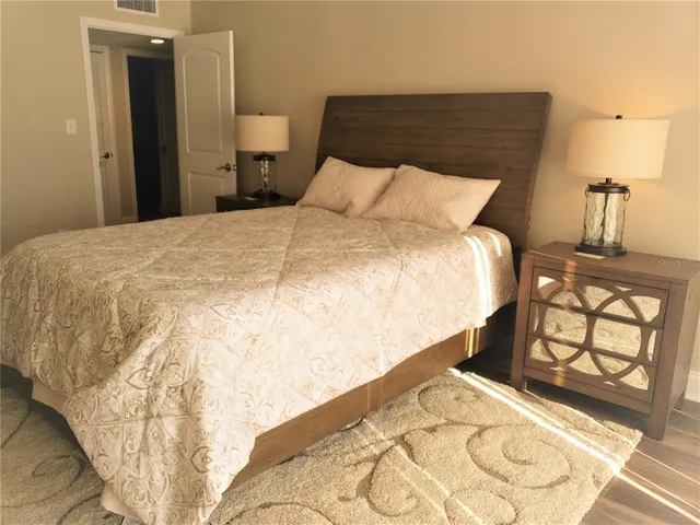 a large bed sitting in a bedroom next to a window