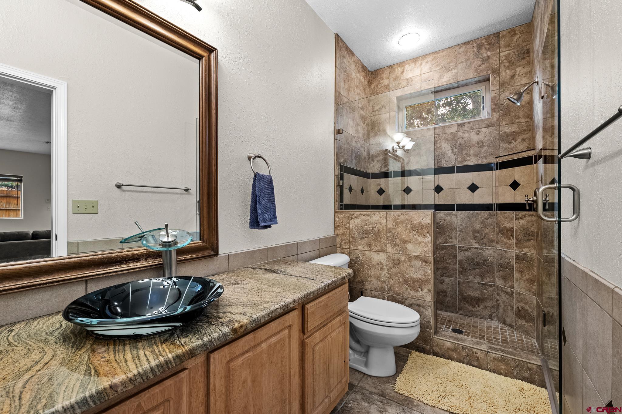 333 Jenkins Ranch Road Durango, CO 81301 - Photo 18 of 27 a bathroom with a granite countertop sink a toilet and a mirror
