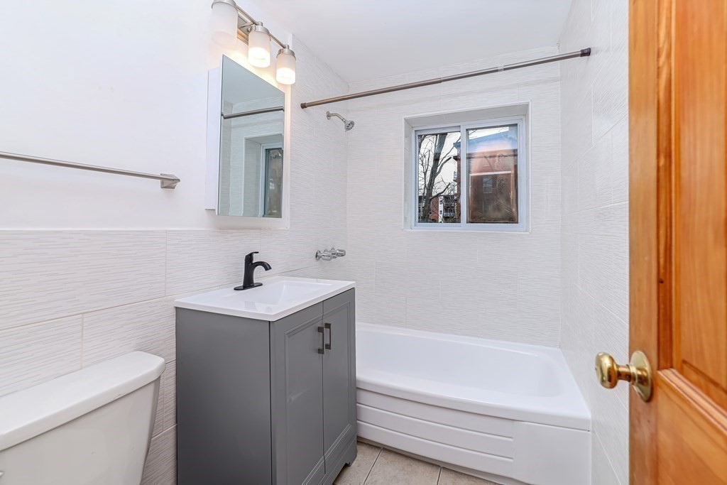 10 Bryon Road, Unit 4 Boston, MA 02467 - Photo 8 of 27 a bathroom with a sink a toilet and shower
