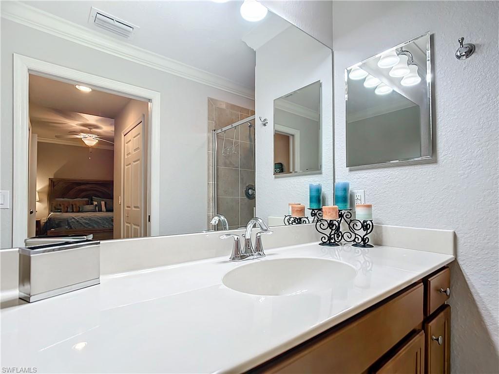 9715 Acqua Court, Unit 127 Naples, FL 34113 - Photo 33 of 50 a bathroom with a sink and a mirror