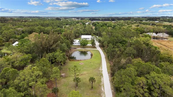 a view of a house with backyard and trees