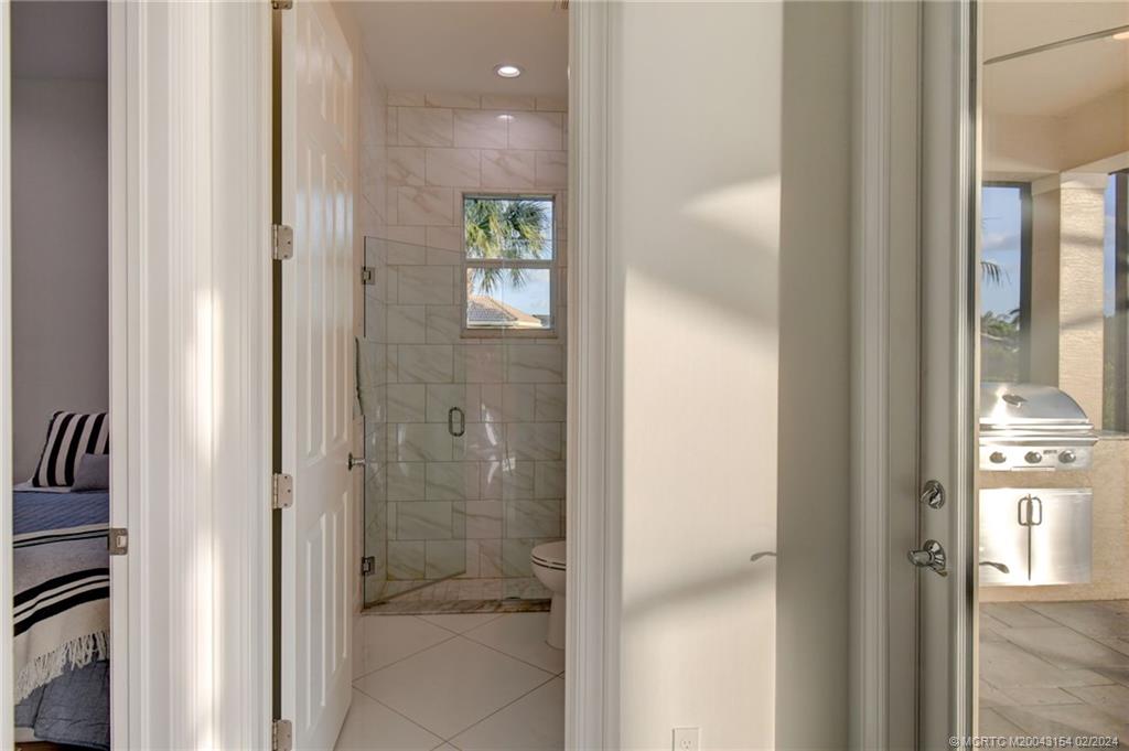 7172 Southeast Pierre Circle Stuart, FL 34997 - Photo 18 of 43 a bathroom with a glass shower door