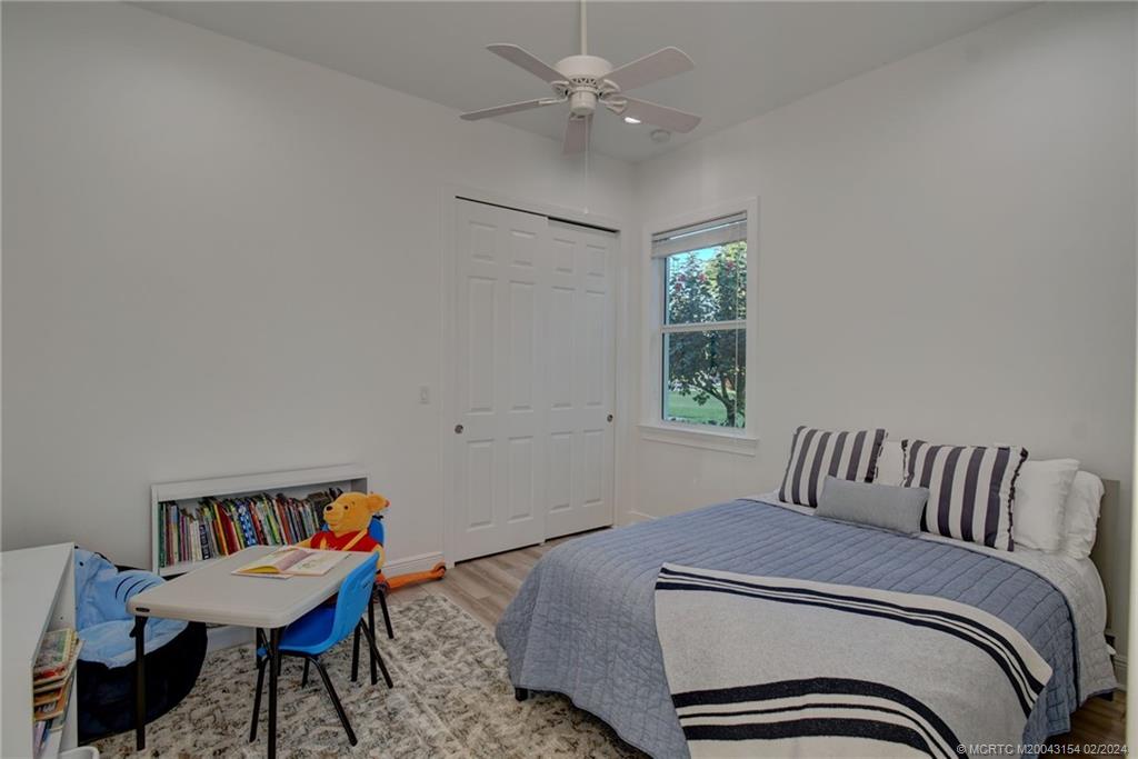 7172 Southeast Pierre Circle Stuart, FL 34997 - Photo 19 of 43 a bedroom with a bed and a window