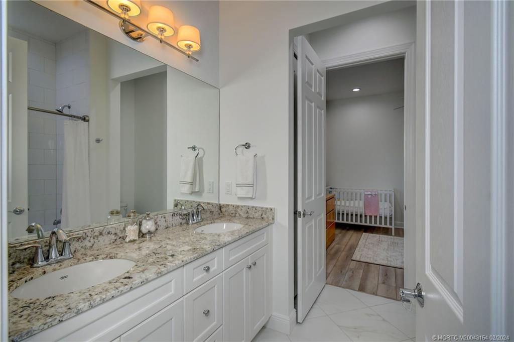 7172 Southeast Pierre Circle Stuart, FL 34997 - Photo 27 of 43 a bathroom with a granite countertop sink and a mirror