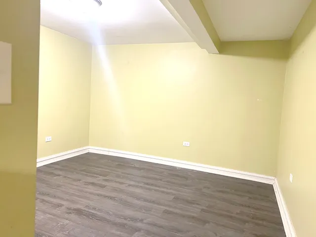 a view of a big room with wooden floor and windows