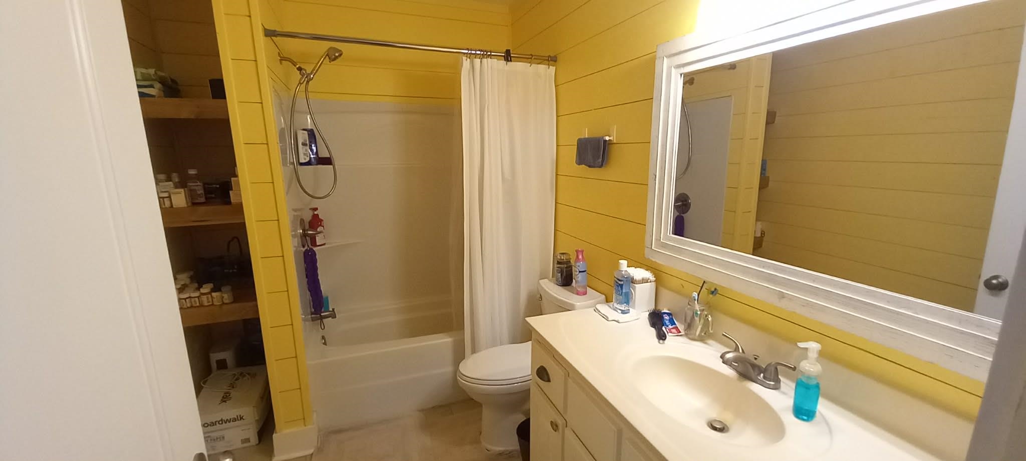 67 Cr 306 Road Iuka, MS 38852 - Photo 16 of 25 Bathroom featuring vanity, wooden walls, and shower / bath combo with shower curtain