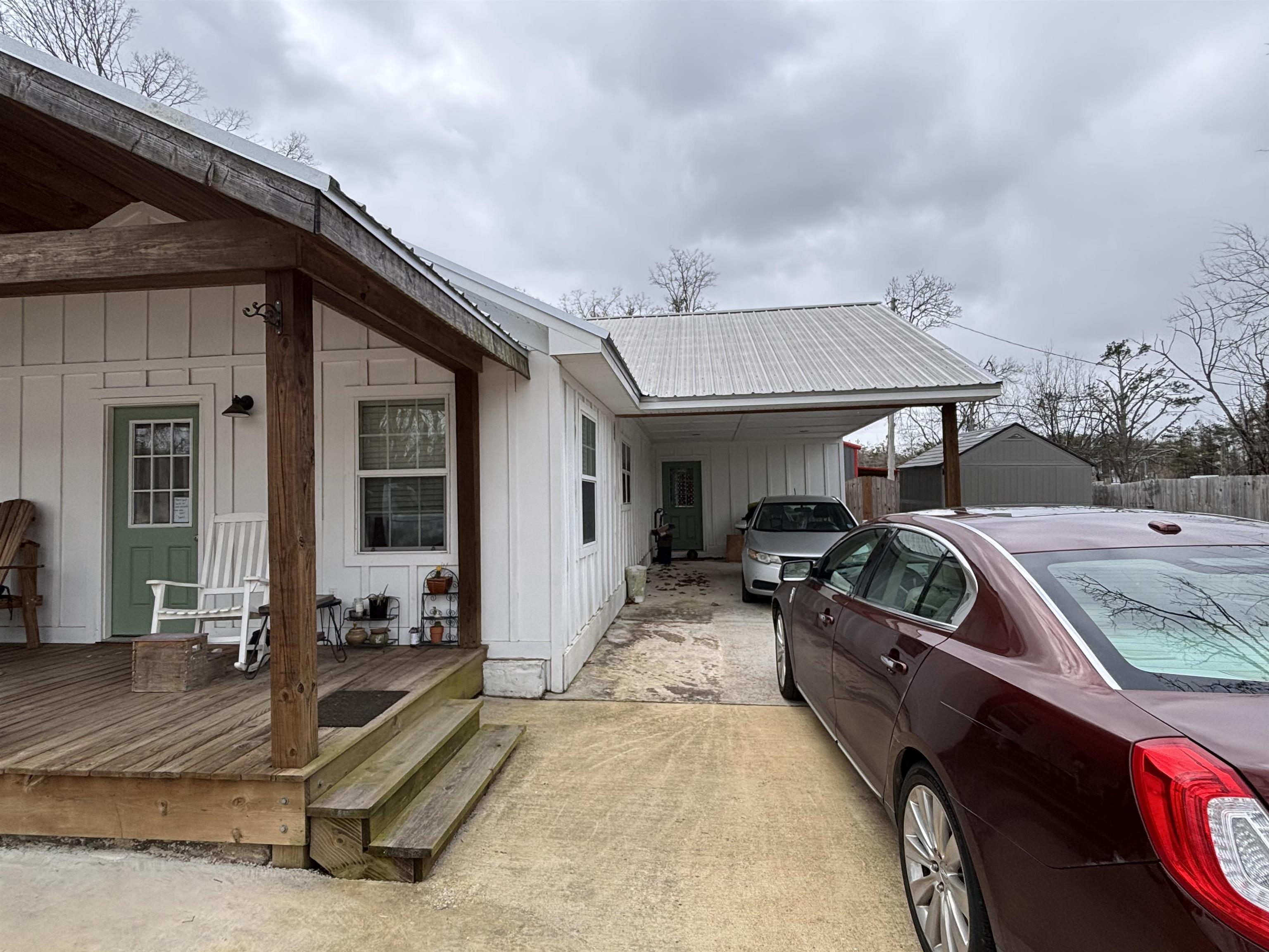 67 Cr 306 Road Iuka, MS 38852 - Photo 18 of 23 View of home's exterior with an attached carport, board and batten siding, a metal roof, and a deck
