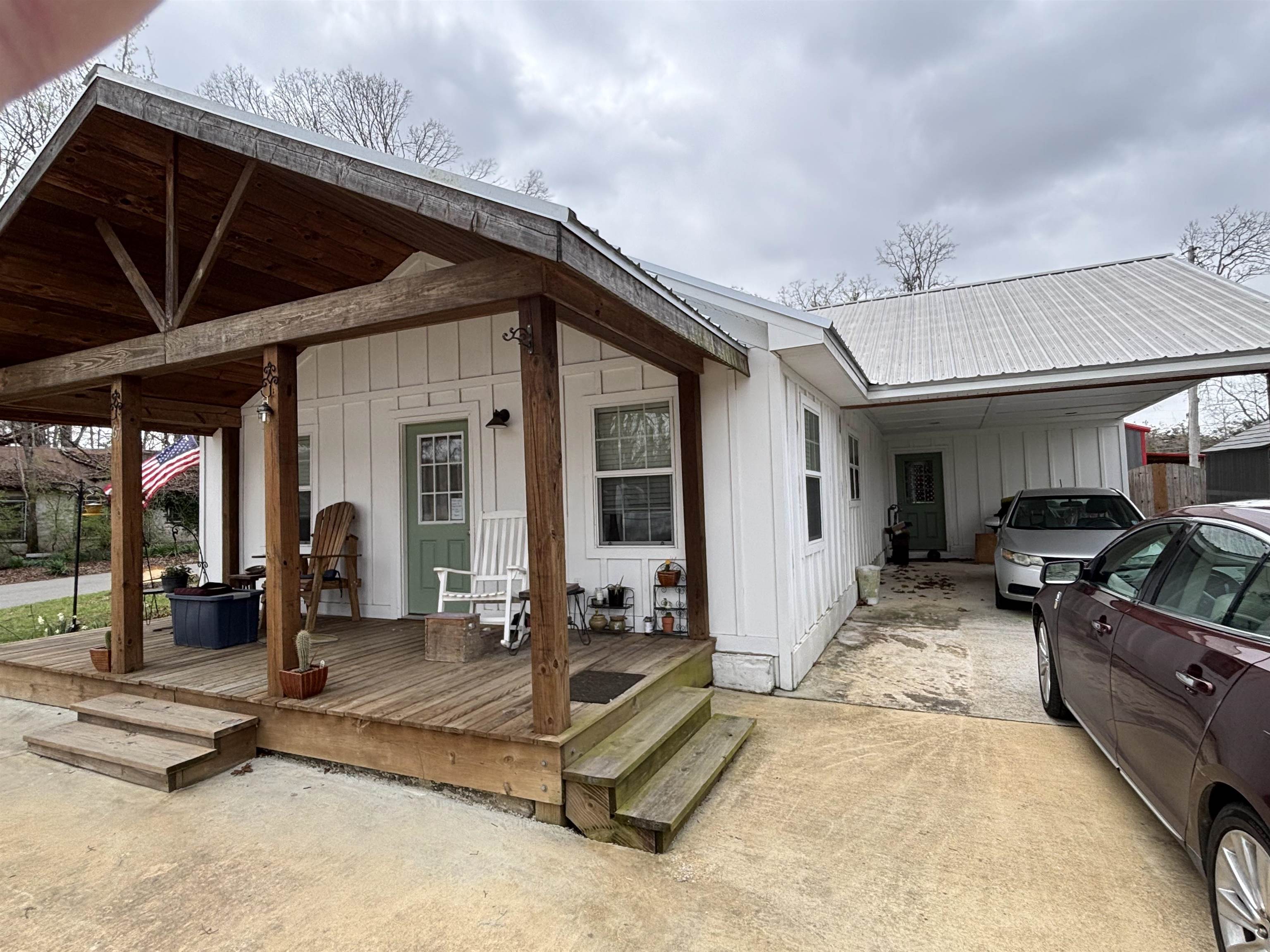 67 Cr 306 Road Iuka, MS 38852 - Photo 19 of 25 View of front of home featuring a carport, a metal roof, board and batten siding, concrete driveway, and a wooden deck