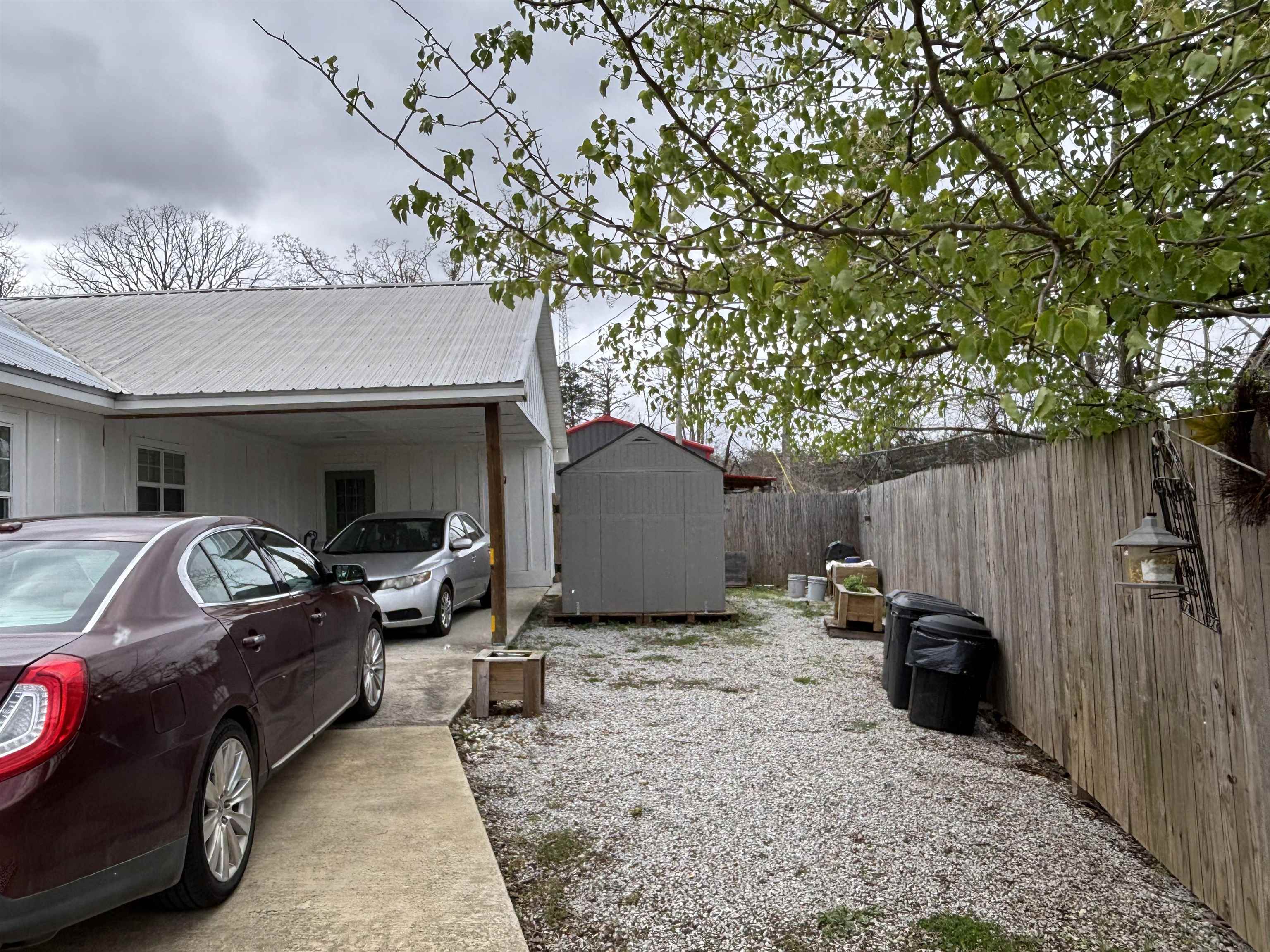 67 Cr 306 Road Iuka, MS 38852 - Photo 21 of 25 View of side of property with a shed, a fenced backyard, a metal roof, and a carport