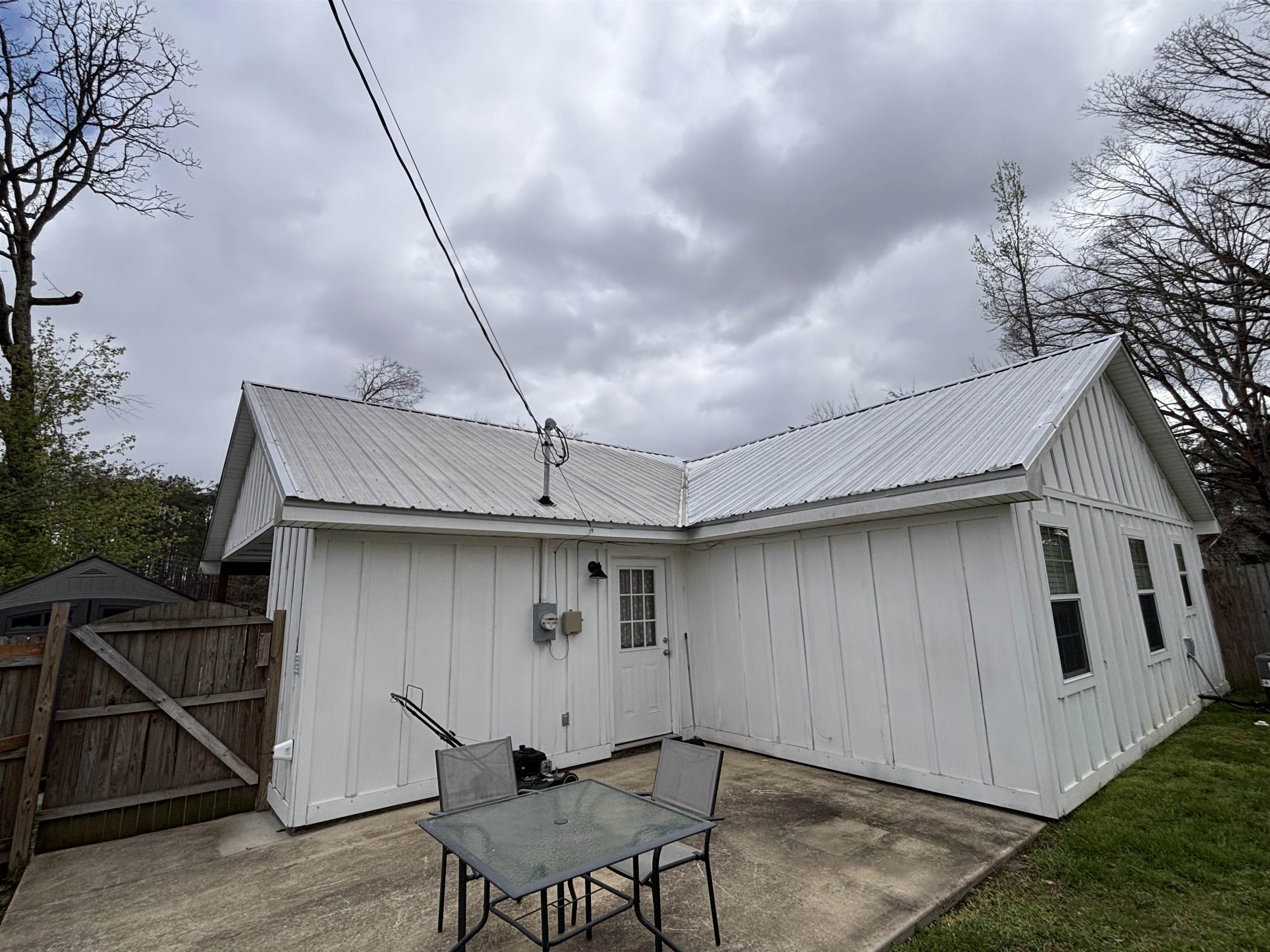 67 Cr 306 Road Iuka, MS 38852 - Photo 25 of 25 Back of property featuring a metal roof, a patio area, board and batten siding, and a gate