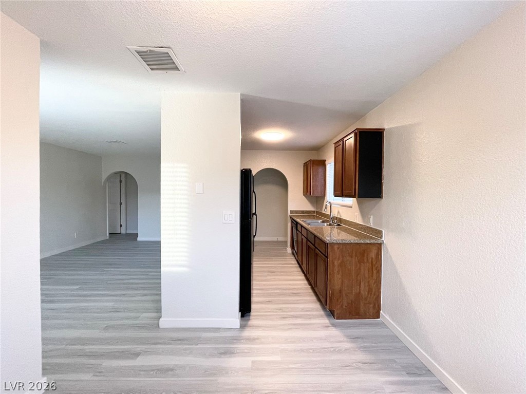 1834 North Decatur Boulevard, Unit 204 Las Vegas, NV 89108 - Photo 5 of 17 A streamlined kitchen and adjoining living area feature continuous plank flooring and arched doorways.
