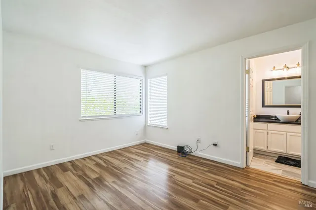 an empty room with a window and wooden floor